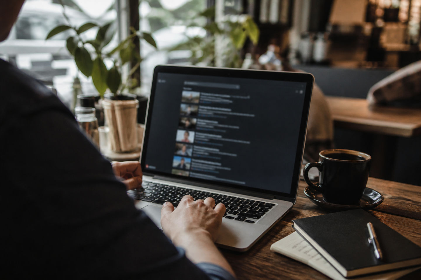 user browsing dark web YouTube links in a cafe